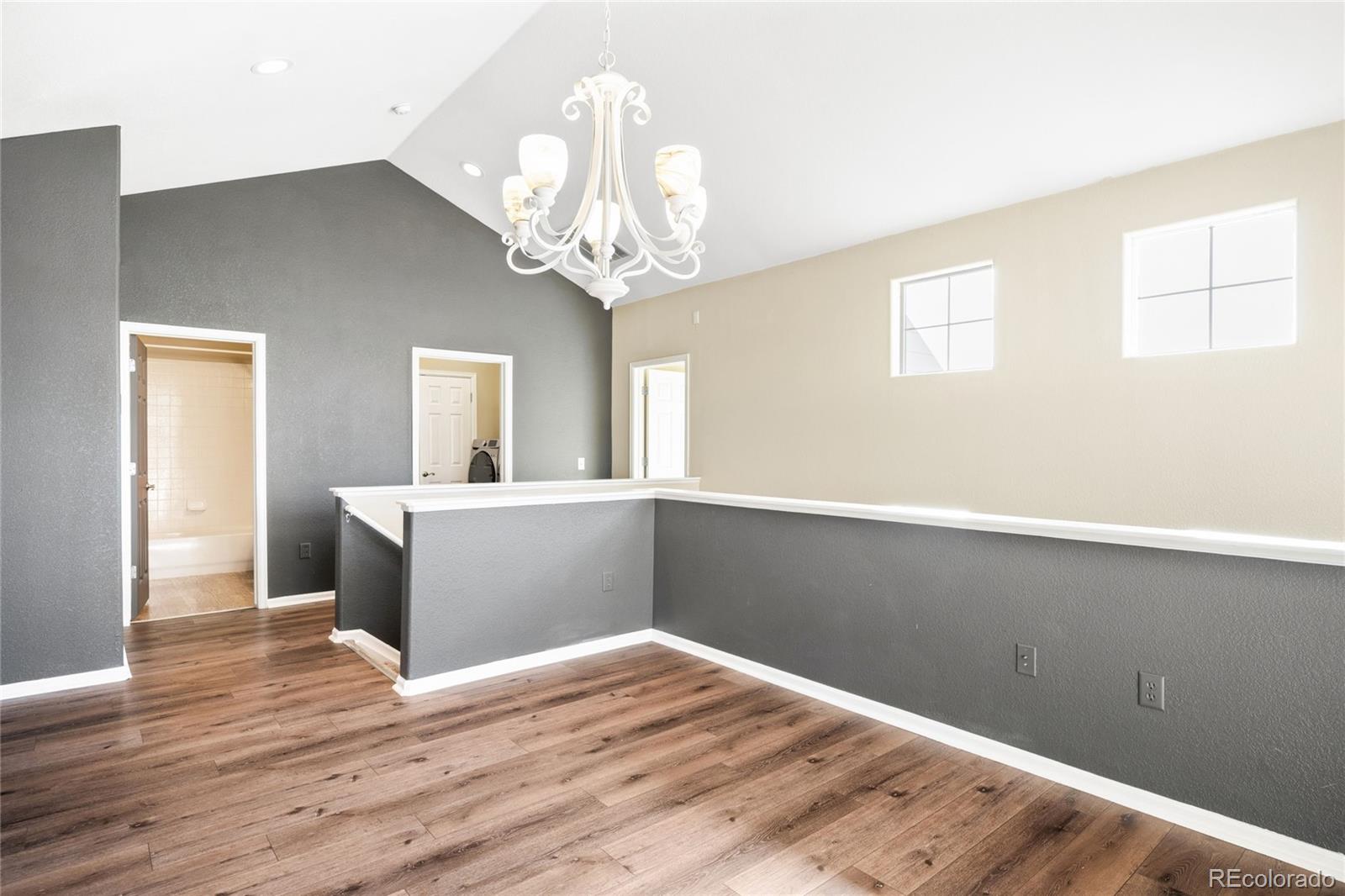 2240 South Vaughn Way, Unit 201 Aurora, CO 80014 - Photo 9 of 34 a view of a room with wooden floor and chandelier