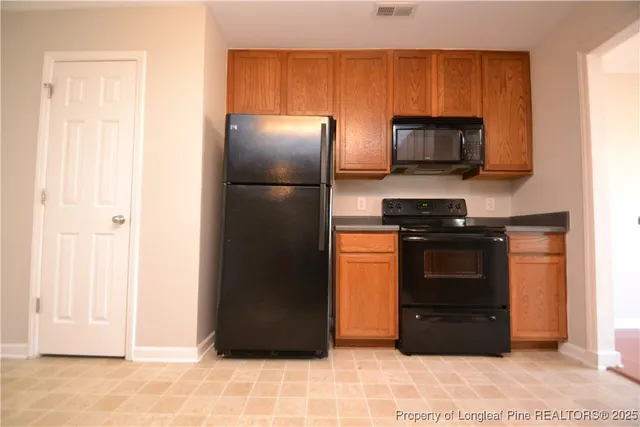a kitchen with stainless steel appliances granite countertop a refrigerator stove and microwave