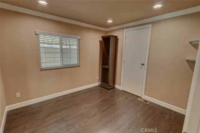 an empty room with wooden floor and a window