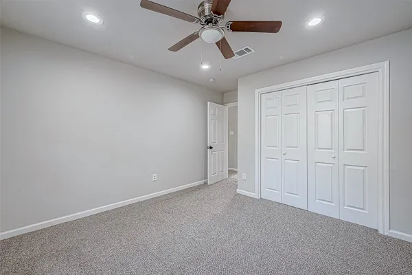 an empty room with chandelier fan