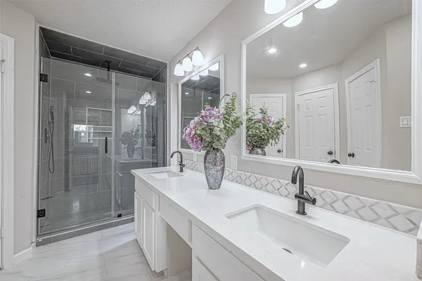 a bathroom with a shower sink and mirror