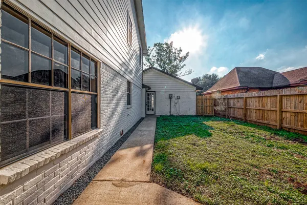 a view of a house with a small yard and wooden fence