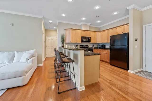 a kitchen with stainless steel appliances a refrigerator a stove a sink cabinets and wooden floor