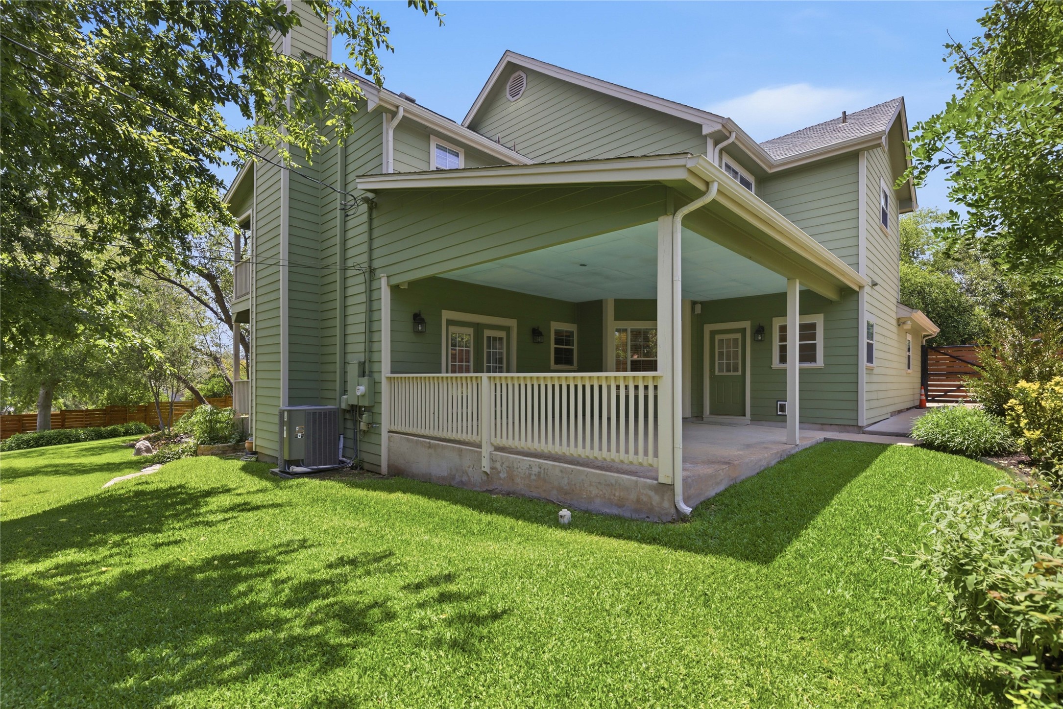 1204 Orlando Road Austin, TX 78733 - Photo 16 of 40 Green siding defines this home's inviting exterior, featuring a spacious covered patio overlooking a manicured yard.