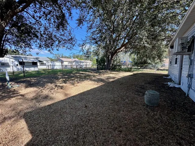 a view of a yard with plants and trees