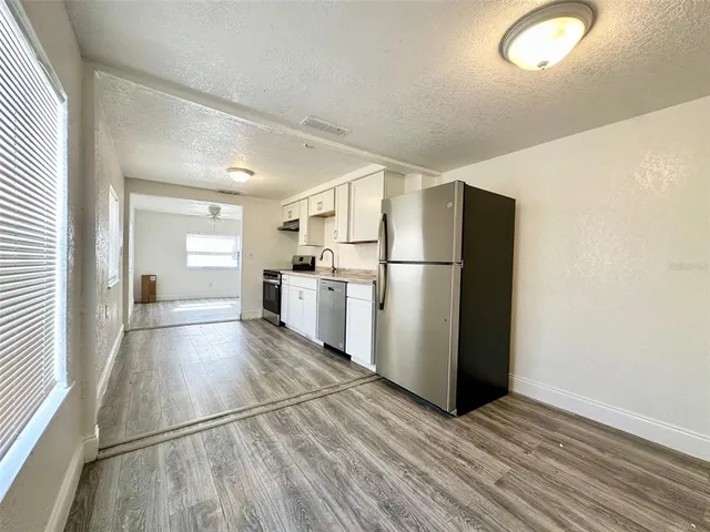 a kitchen with a refrigerator and a stove top oven