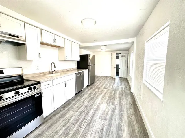 a kitchen with a sink a stove and a window