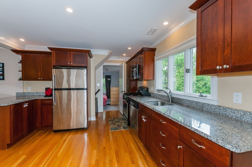 38 Lafayette Street, Unit 38 Arlington, MA 02474 - Photo 2 of 13 a kitchen with stainless steel appliances granite countertop a refrigerator a sink dishwasher a stove and white countertops with wooden floor