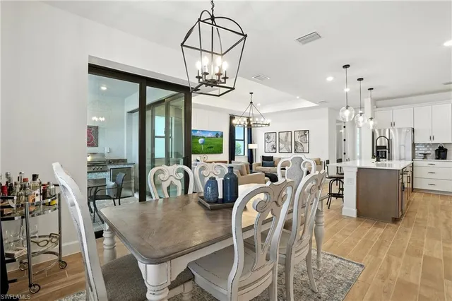 a view of a dining room and livingroom with furniture wooden floor a chandelier
