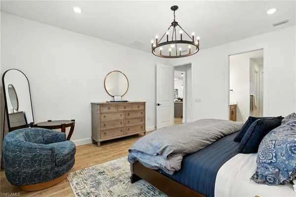 a bedroom with bed and a chandelier
