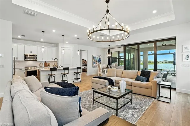 a living room with furniture kitchen and a chandelier