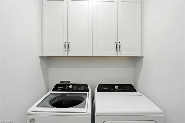 a kitchen with white cabinets and white appliances