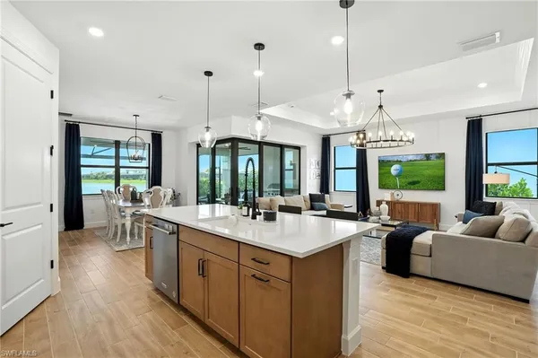 a large kitchen with kitchen island a large counter space a sink appliances and a large window