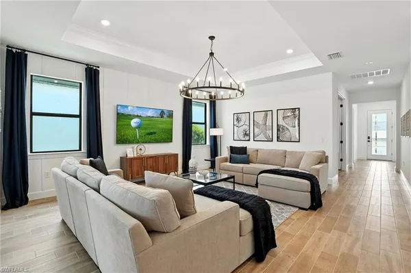 a living room with furniture a large window and a chandelier