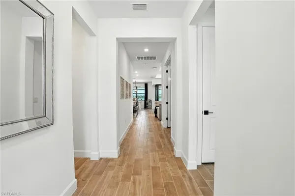 a view of a hallway with wooden floor