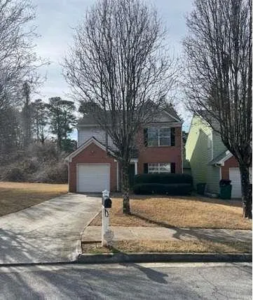 a front view of a house with a yard covered in snow