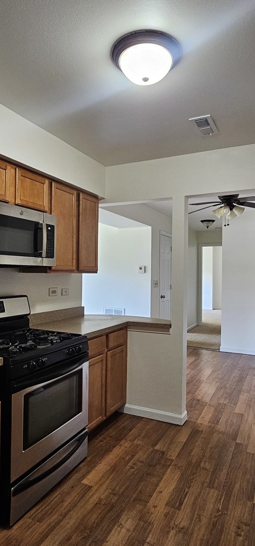 833 Village Quarter Road, Unit A3 West Dundee, IL 60118 - Photo 10 of 27 a kitchen with stainless steel appliances granite countertop a stove and a microwave