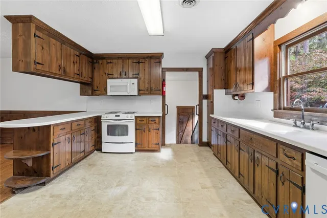 a spacious bathroom with stainless steel appliances granite countertop a sink and dishwasher with wooden floor