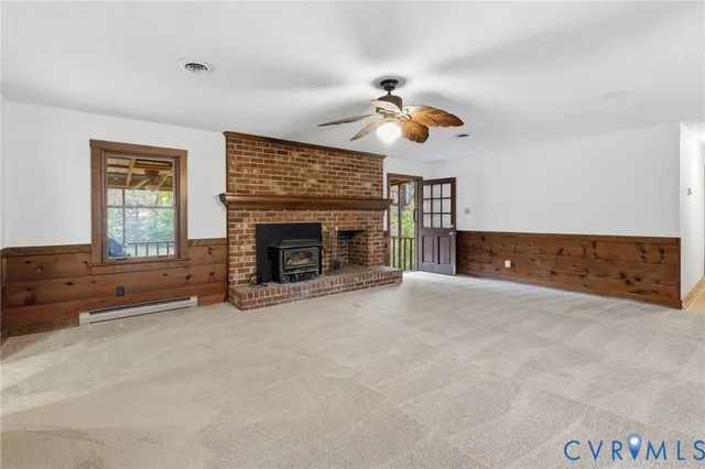 an empty room with windows and fireplace