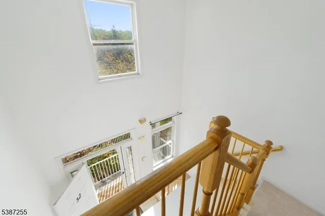 a view of staircase with railing and white walls