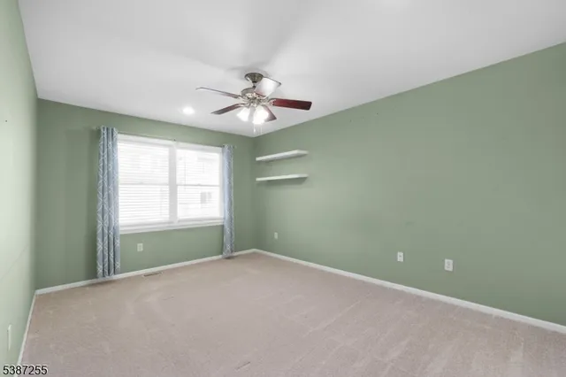 an empty room with a window and a ceiling fan