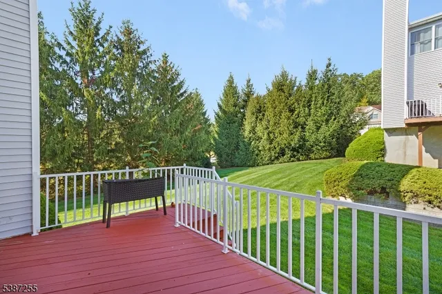 a view of a deck with wooden floor and fence next to a yard