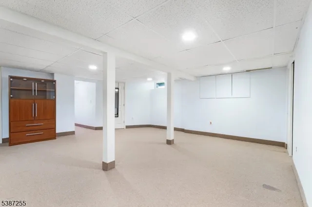 an empty room with a cabinet and mirrors