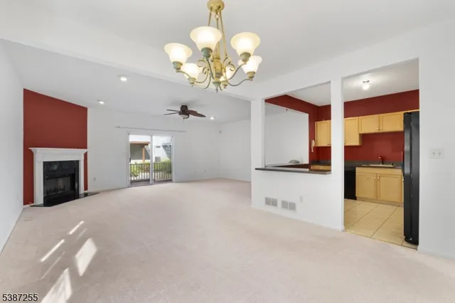 a view of an empty room with a fireplace and a window