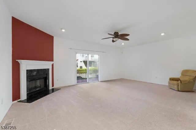 a view of an empty room with a fireplace and a window