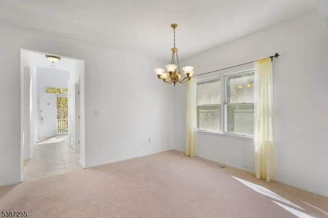 an empty room with chandelier and windows