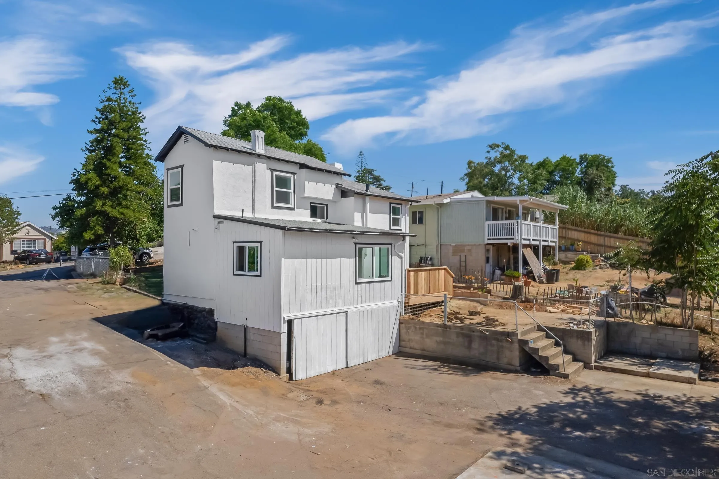 8726 Almond Road Lakeside, CA 92040 - Photo 27 of 31 a view of a white house next to a yard with many windows