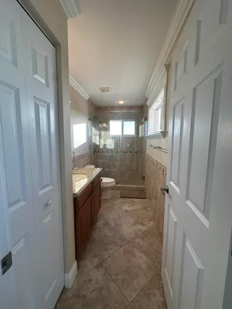 a bathroom with a granite countertop sink toilet and shower
