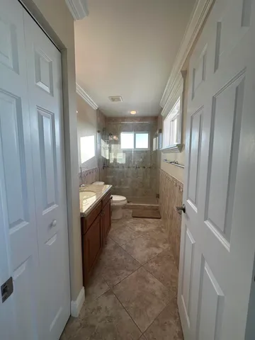 a bathroom with a granite countertop sink toilet and shower