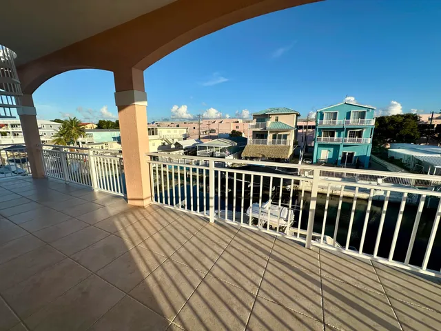 a kitchen with stainless steel appliances kitchen island granite countertop a refrigerator a stove top oven a sink with island and chairs