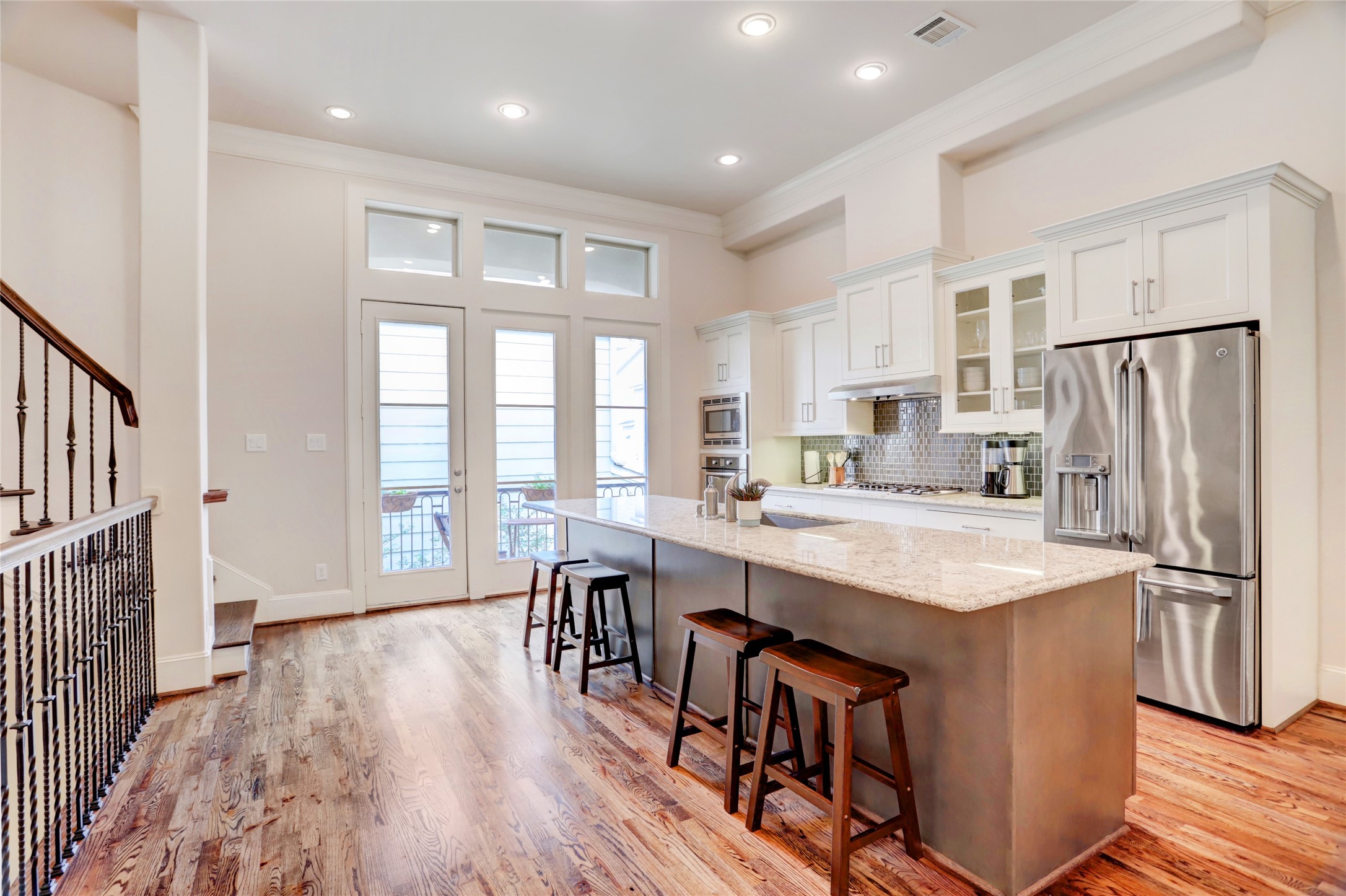 1348 West 25th Street Houston, TX 77008 - Photo 16 of 34 a kitchen with stainless steel appliances granite countertop a refrigerator a sink dishwasher a stove and a dining table with wooden floor