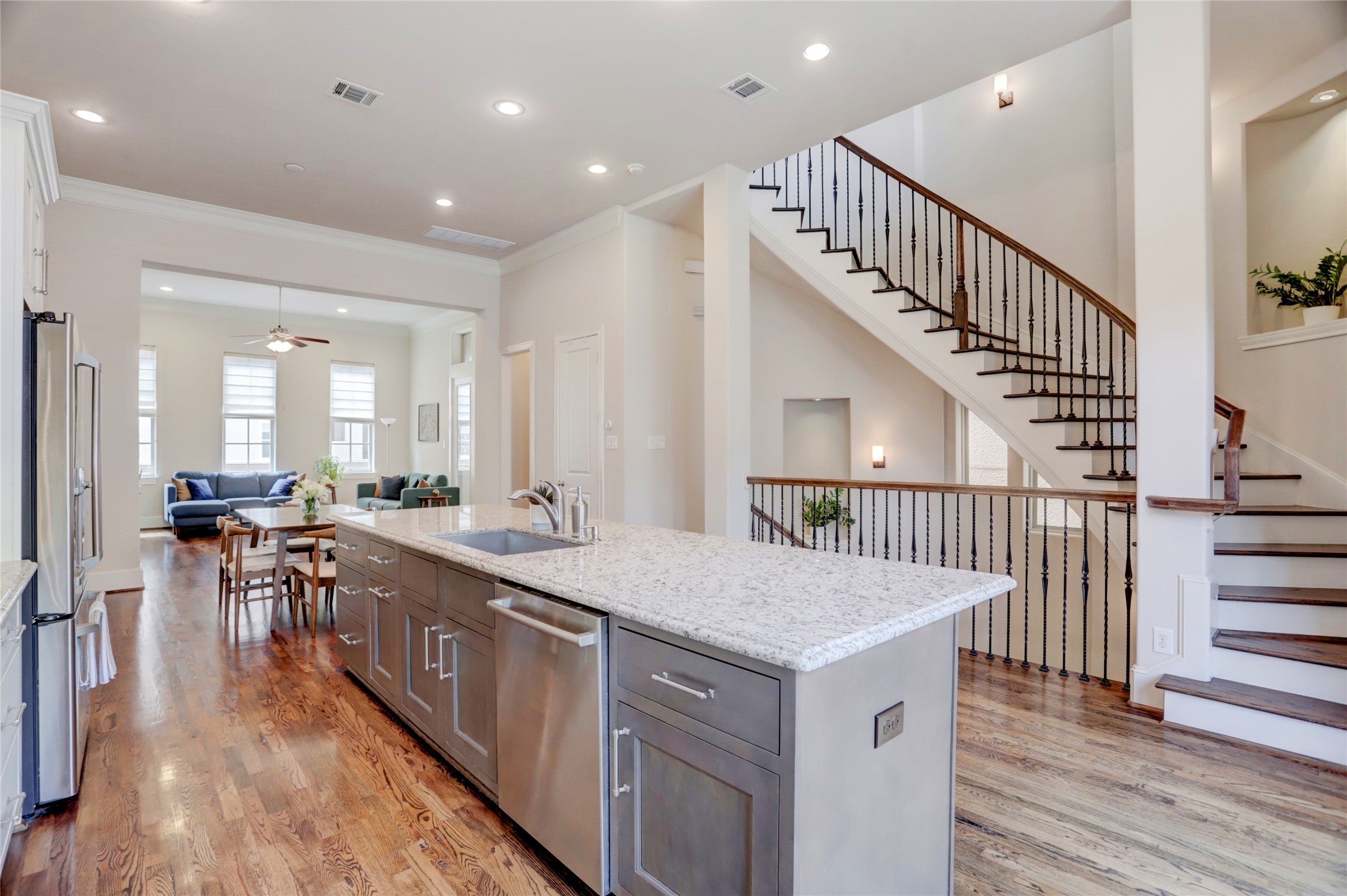 1348 West 25th Street Houston, TX 77008 - Photo 18 of 34 View of all the softclose shaker style cabinets and softclose drawers. Pretty brushed nickel hardware on cabinets. Notice the electric plugs on side of the island. View of staircase leading to 3rd floor.