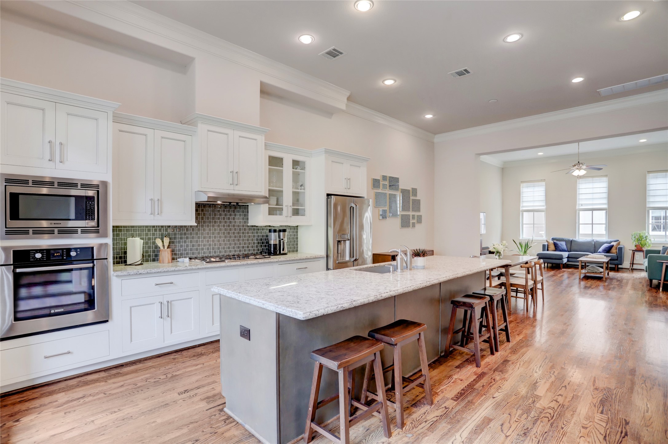 1348 West 25th Street Houston, TX 77008 - Photo 2 of 34 a kitchen with stainless steel appliances a stove a sink a refrigerator and white cabinets with wooden floor