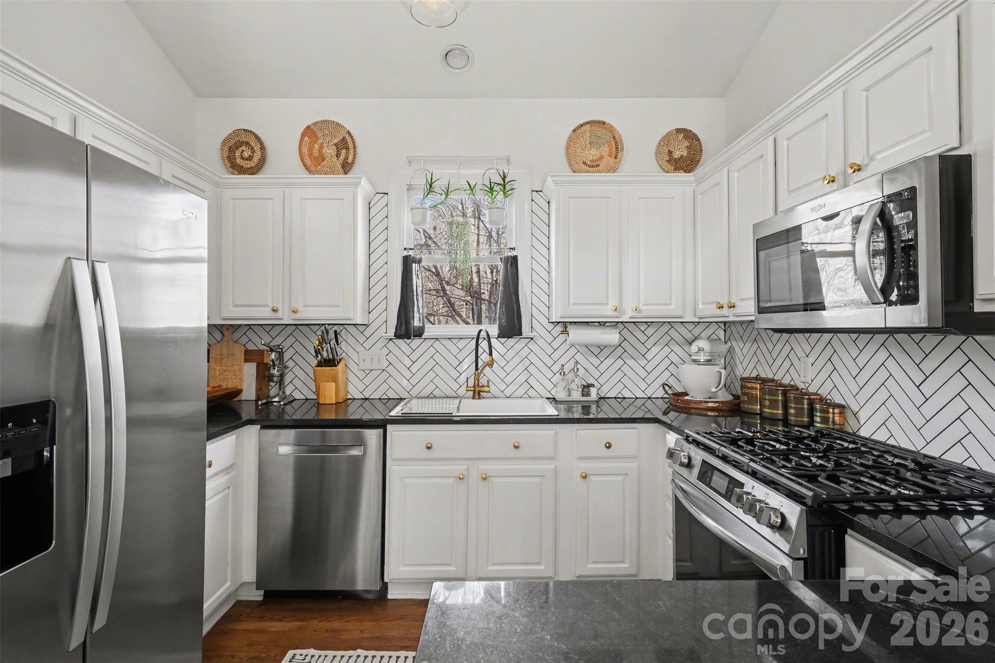 136 Spencer Street Davidson, NC 28036 - Photo 19 of 42 a kitchen with stainless steel appliances granite countertop a stove a sink and a refrigerator