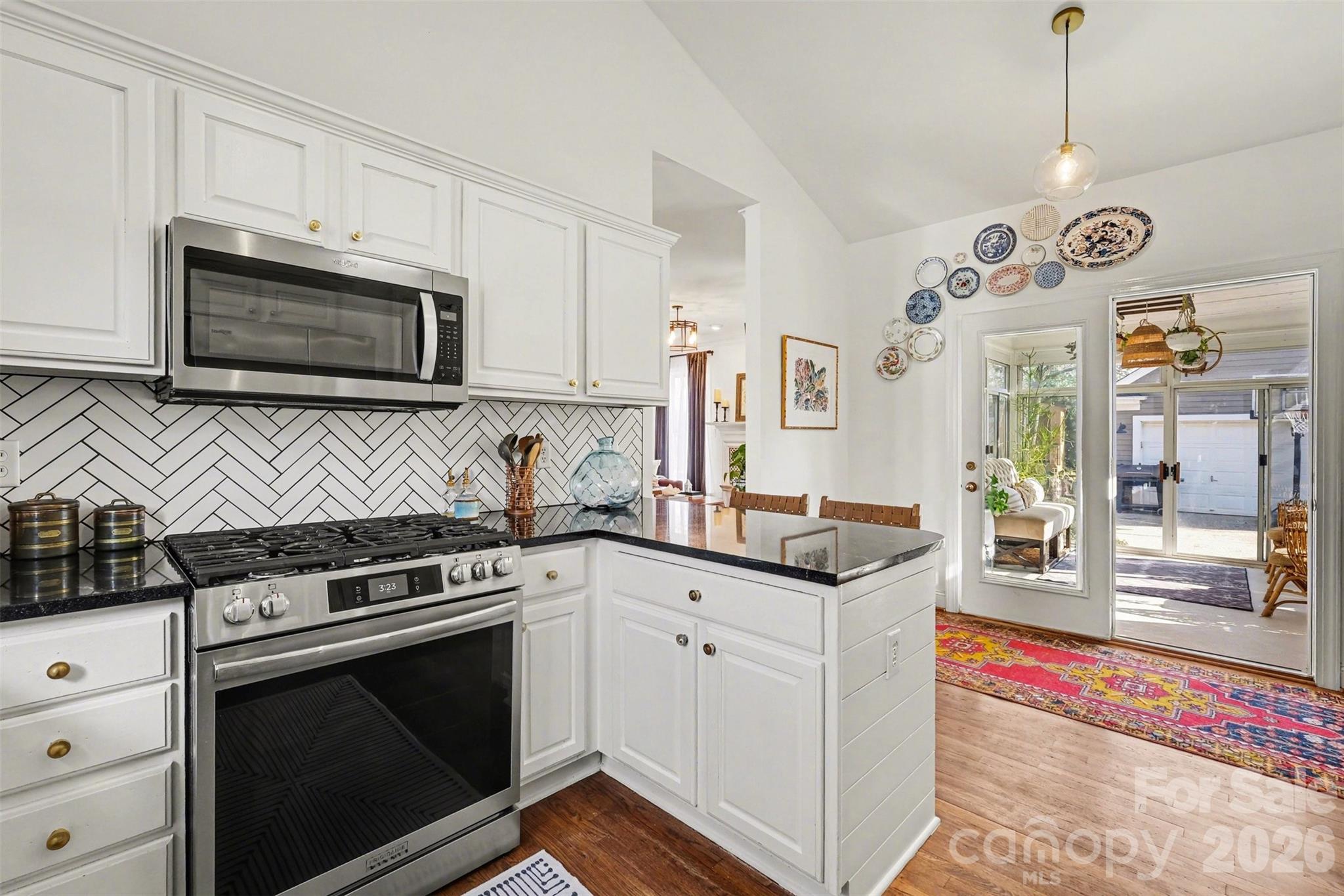 136 Spencer Street Davidson, NC 28036 - Photo 20 of 42 a kitchen with stainless steel appliances granite countertop a stove and a microwave