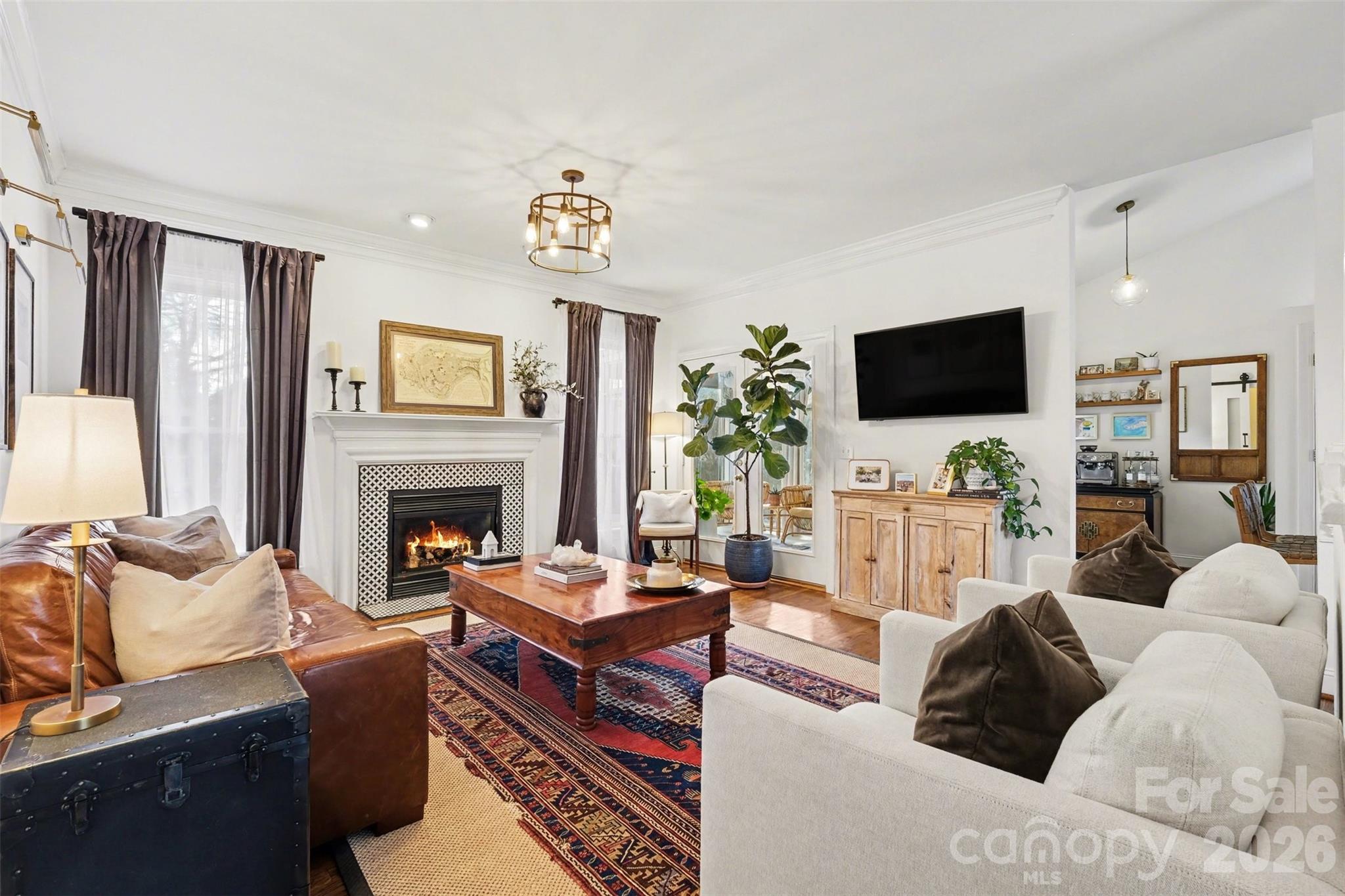 136 Spencer Street Davidson, NC 28036 - Photo 32 of 42 a living room with furniture a fireplace and a flat screen tv