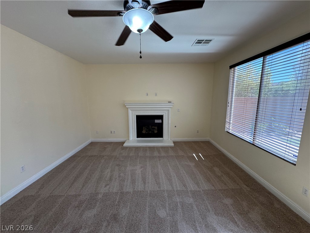 1333 Jamesbury Road Las Vegas, NV 89135 - Photo 15 of 43 A comforting fireplace provides warmth in this generously proportioned living room with plush carpeting.