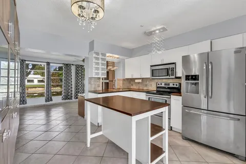 a kitchen with stainless steel appliances granite countertop a refrigerator and a stove top oven