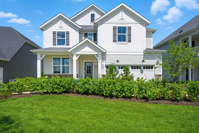 a front view of a house with a yard and trees