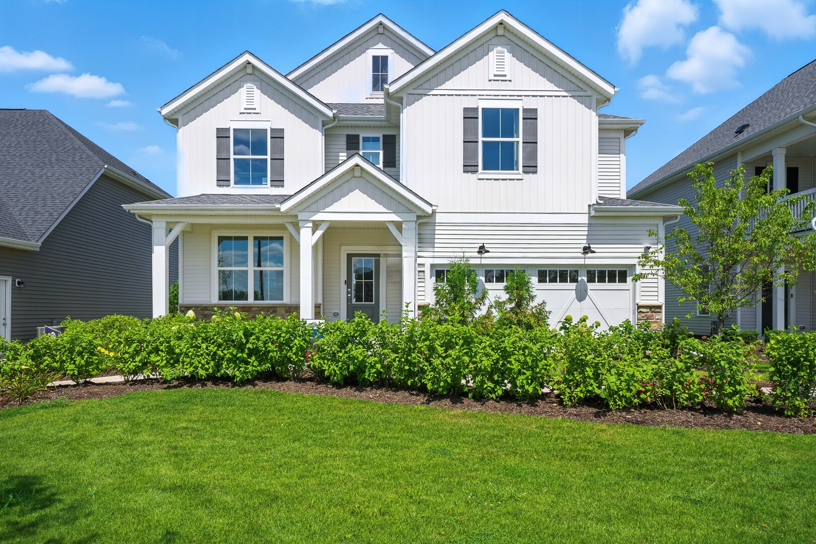 a front view of a house with a yard and trees