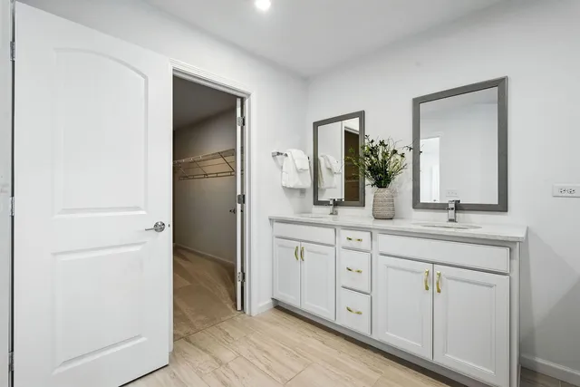 a spacious bathroom with a double vanity sink and mirror