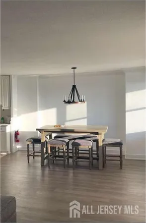 a living room with chairs wooden floor and a table
