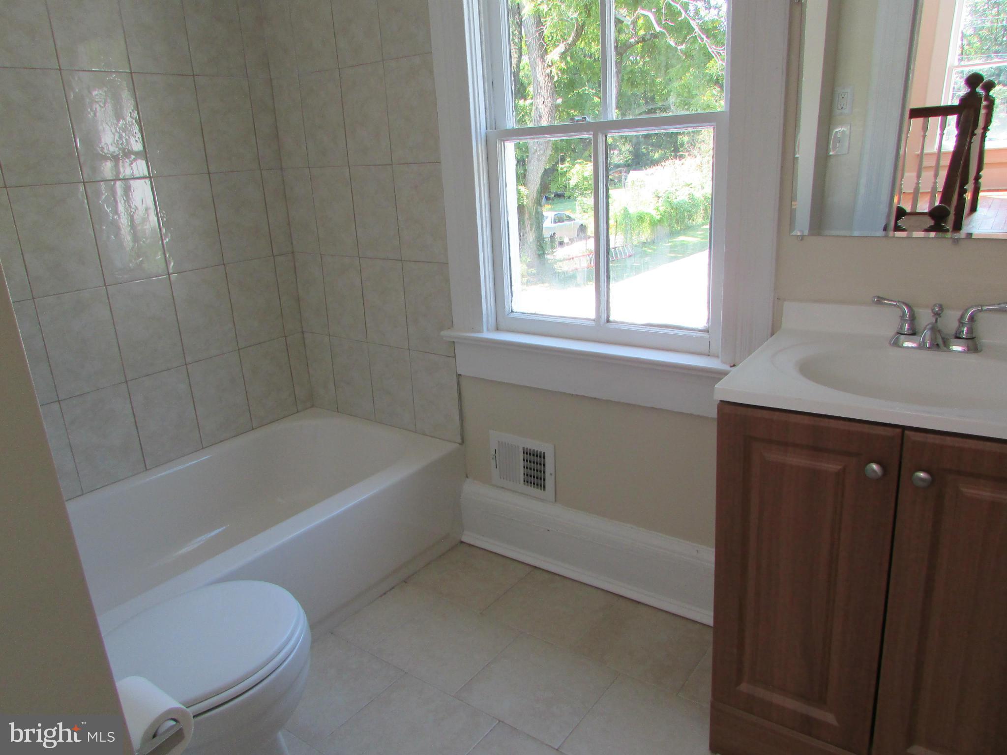 9520 Main Street Manassas, VA 20110 - Photo 13 of 19 a bathroom with a tub a sink and a window