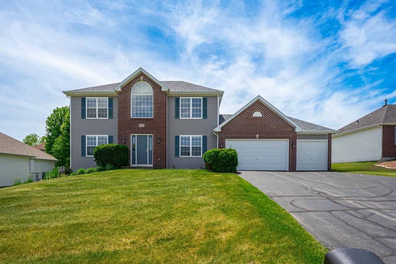 676 Elberon Way Roscoe, IL 61073 - Photo 2 of 30 a front view of a house with a yard and garage