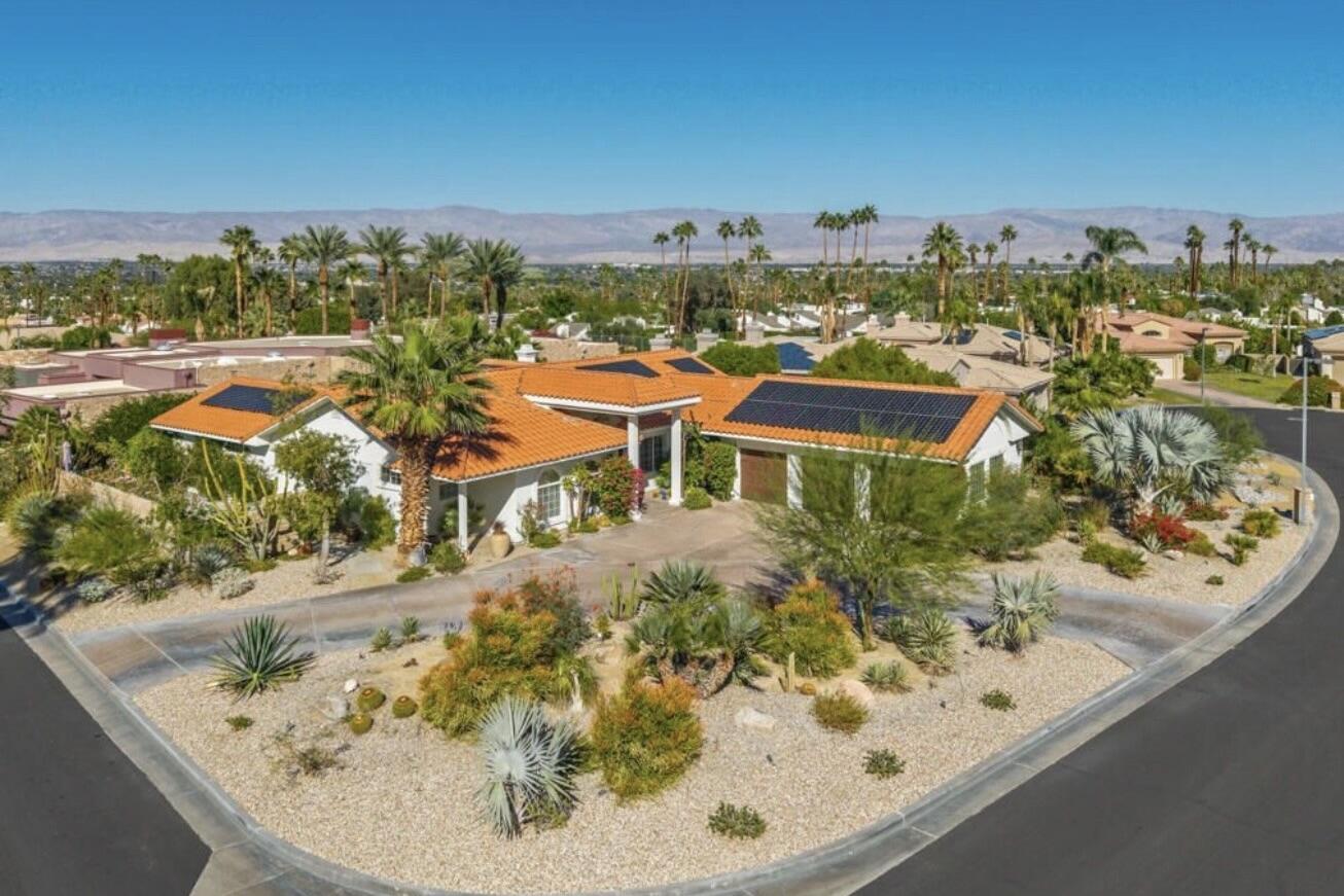 an aerial view of a house with a yard and lake view