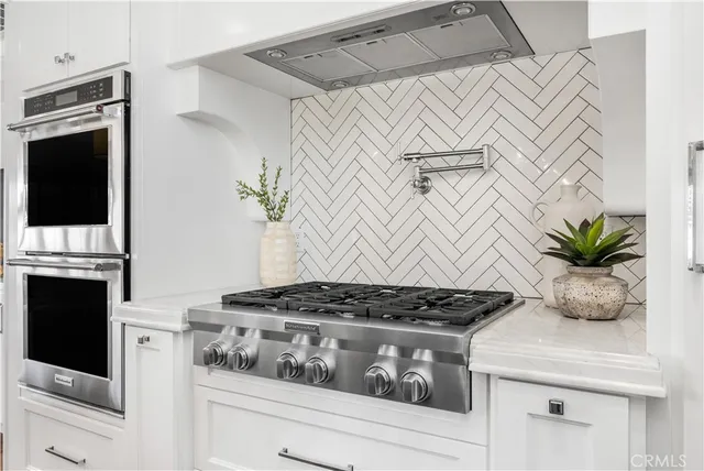 a kitchen with a stove and white cabinets